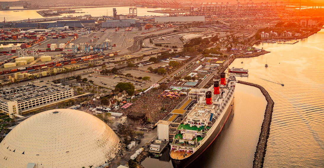 Sunlit Queen Mary ship gleaming against the Dreamstate Festival skyline