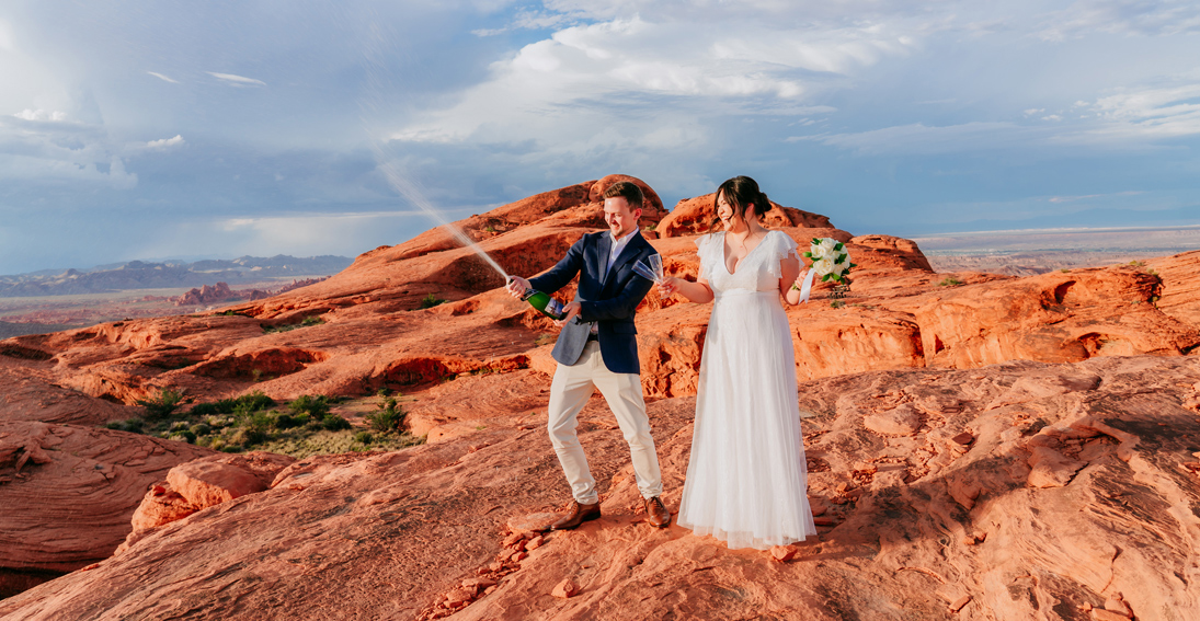 Bride and groom enjoying a celebratory champagne toast with breathtaking views at the exclusive plateau of Valley of Fire